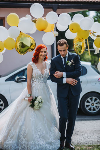 Full length of couple holding bouquet
