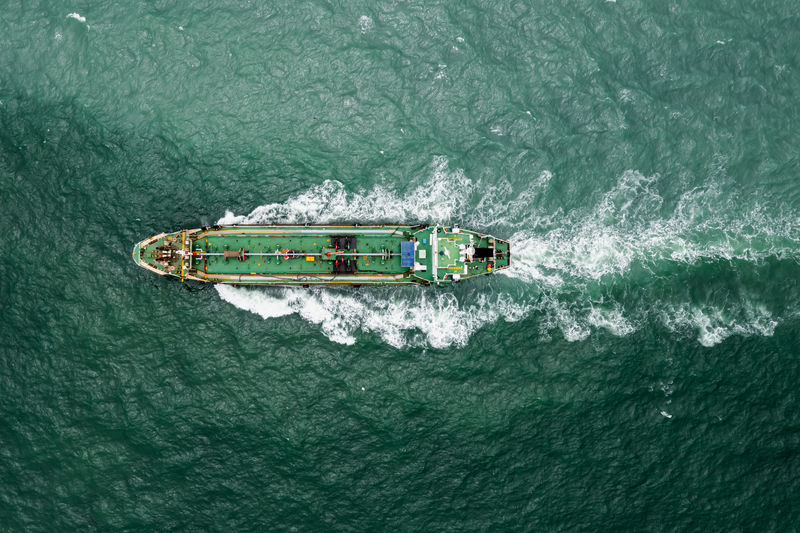 Aerial top view oil thanker ship and lpg gass full speed in green sea transportation