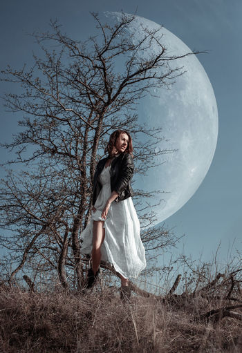 Digital composite image of woman standing against moon