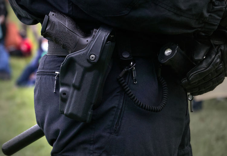 Pistol in the holster of the black uniform trousers of a german police officer
