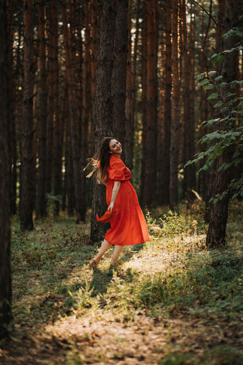 Peace of mind, breathing fresh air. alone woman in red dress enjoys the tranquility and calm