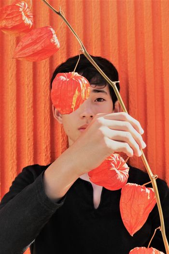 Portrait of boy holding red umbrella