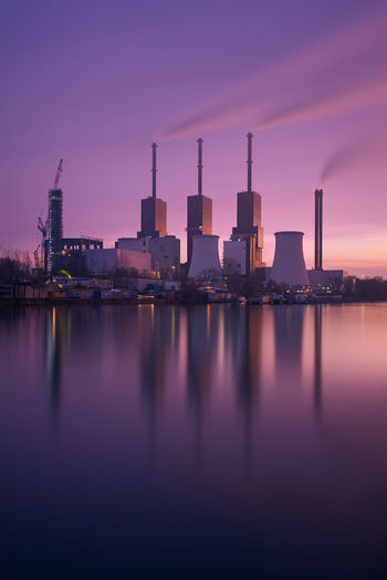 REFLECTION OF BUILDINGS IN WATER AT SUNSET