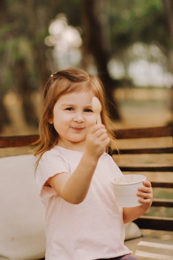 Portrait of young woman looking away while sitting outdoors