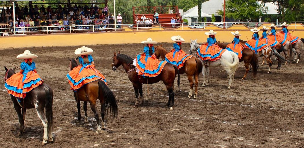 Women riding horses during charreada event