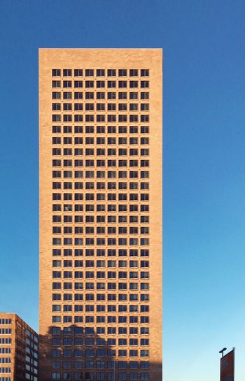 Low angle view of skyscraper against clear blue sky