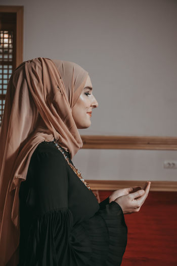 Woman in traditional clothing praying at mosque