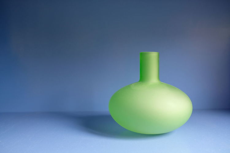 Close-up of green bottle against blue background