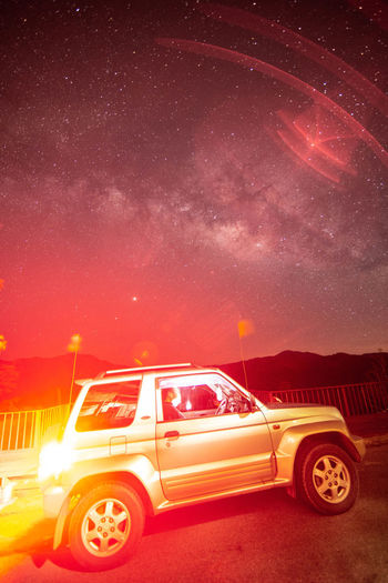 Digital composite image of illuminated car against sky