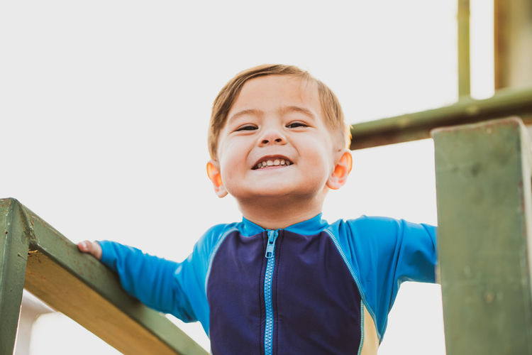 Portrait of smiling boy looking against clear sky
