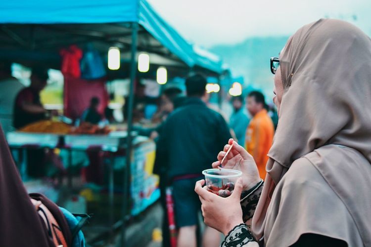 Woman having food at market stall