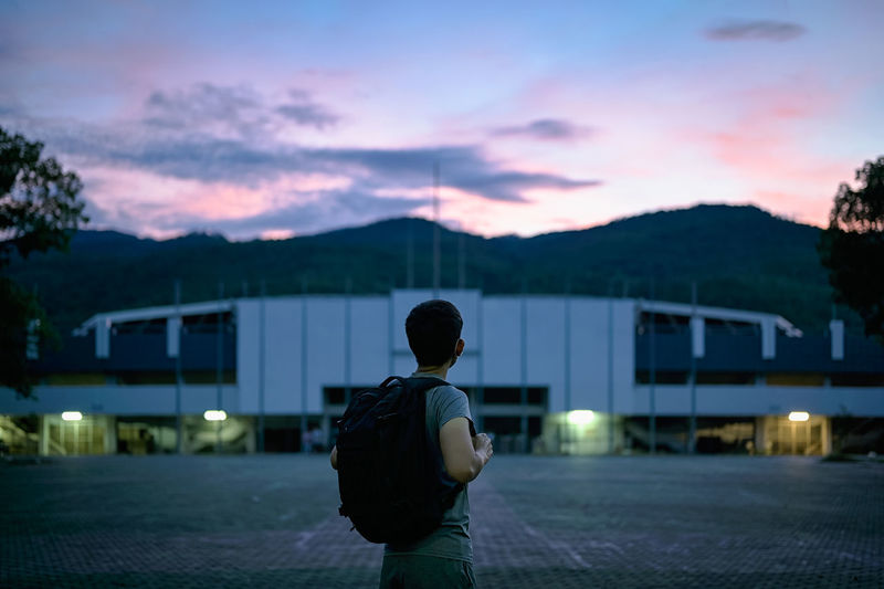 Back view point of young man backpacker looking at the sky in blue hour ,mindfulness concept