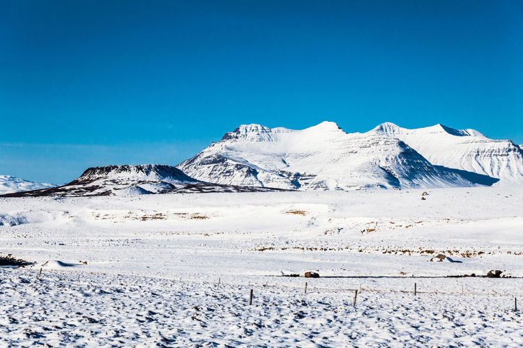 Scenic view of snowcapped mountains against clear blue sky