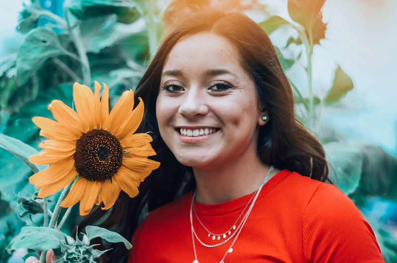 Portrait of smiling woman with sunflower
