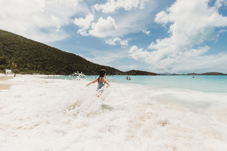 Girl plays in the tropical waves in the caribbean islands
