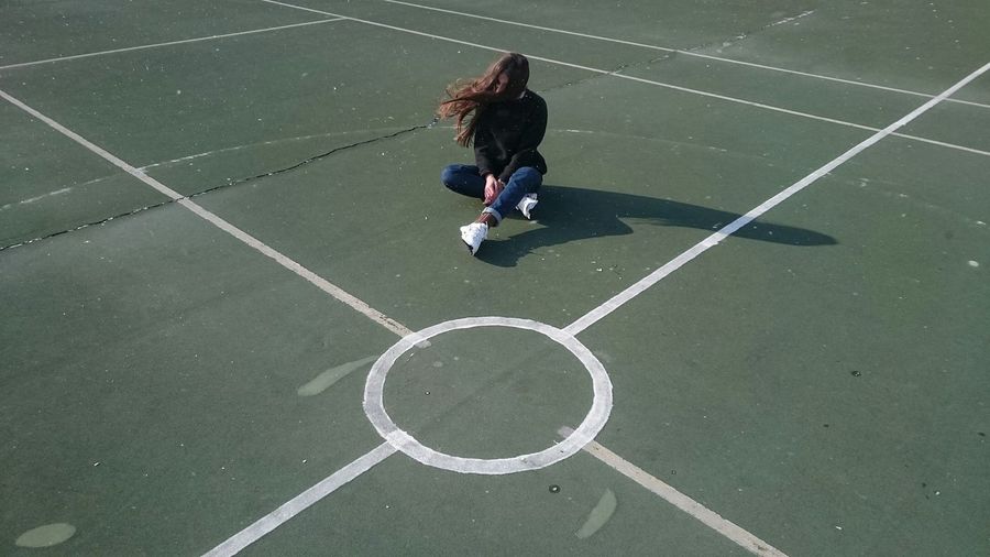 High angle view of woman sitting on playing field