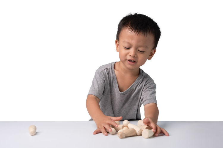 Boy playing with baby against white background