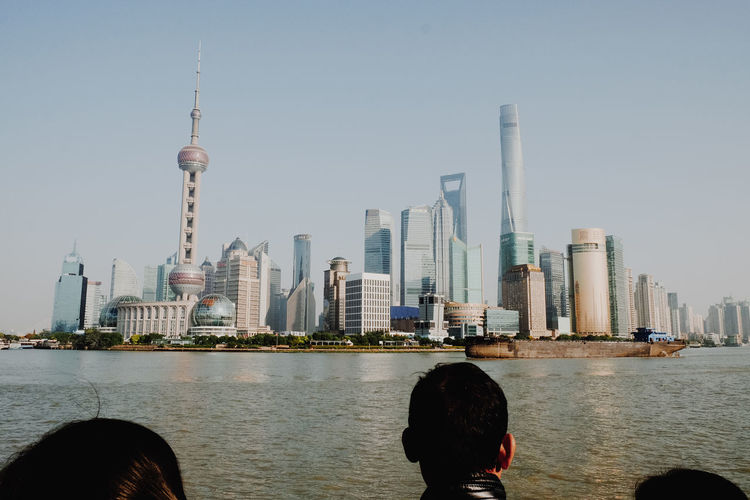 People on city skyline against clear sky