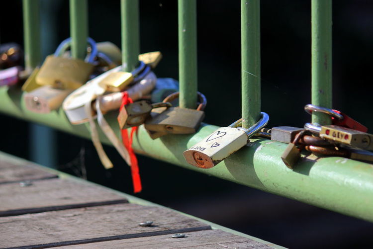 Close-up of love locks on railing at bridge