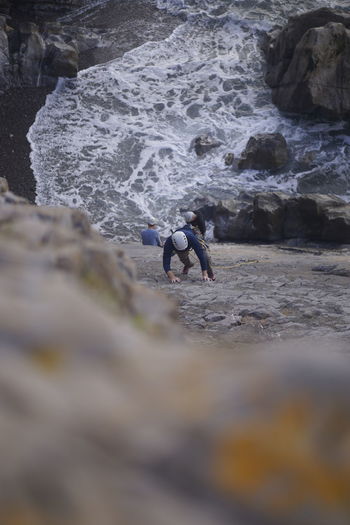 Man surfing on rock in sea