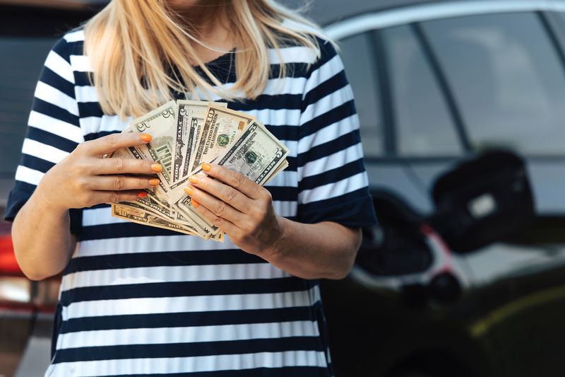 Midsection of woman holding paper currency