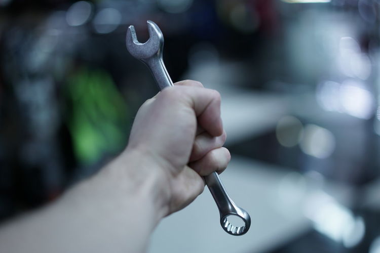 Cropped hand of man holding wrench