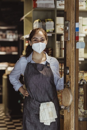 Female owner with hand on hip in store during covid-19