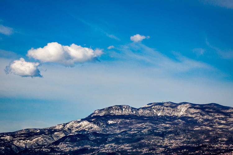 Scenic view of snowcapped mountains against blue sky