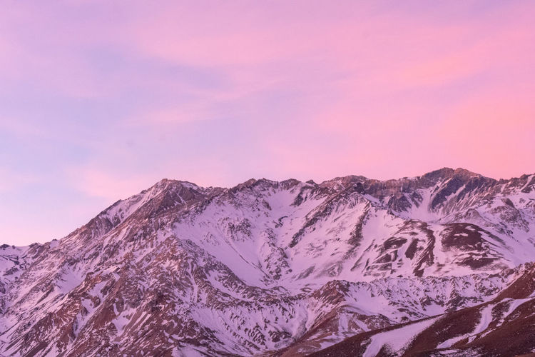 SCENIC VIEW OF SNOWCAPPED MOUNTAINS AGAINST SKY AT SUNSET