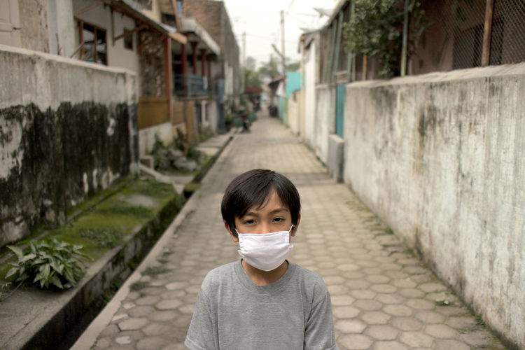 Portrait of boy on street wearing mask