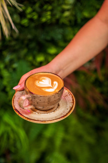 Cropped hand of woman holding coffee