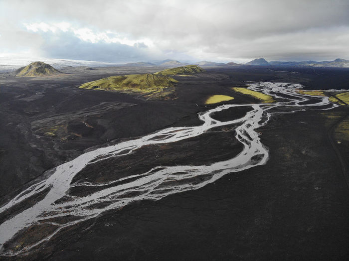 Aerial view of stream flowing on volcanic landscape