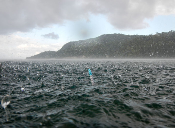 Scenic view of sea during rain and snorkel comes out of the water