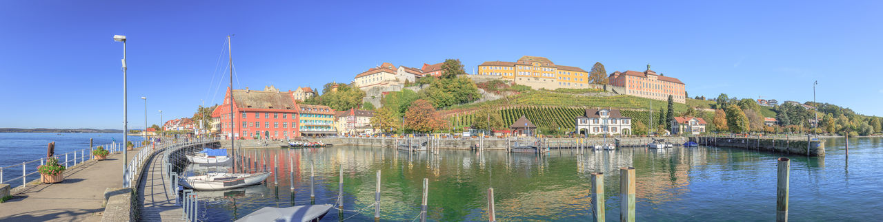 Panoramic view of sea and buildings against clear blue sky