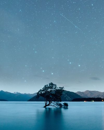 Scenic view of lake against sky at night