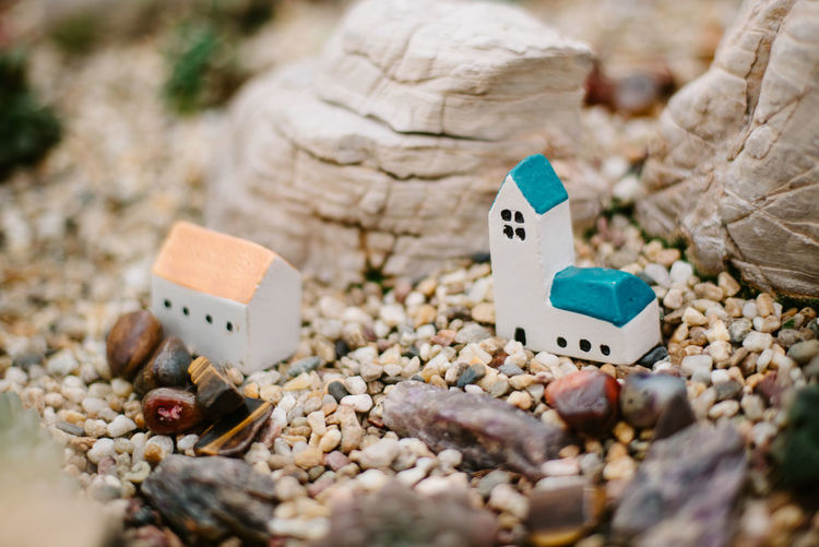 Close-up of model house amidst small rocks