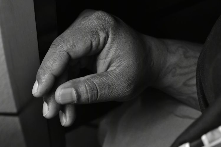 Close-up of workers hand resting on the bed