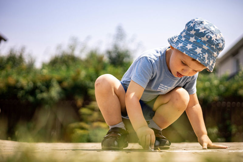 Rear view of boy playing with plants