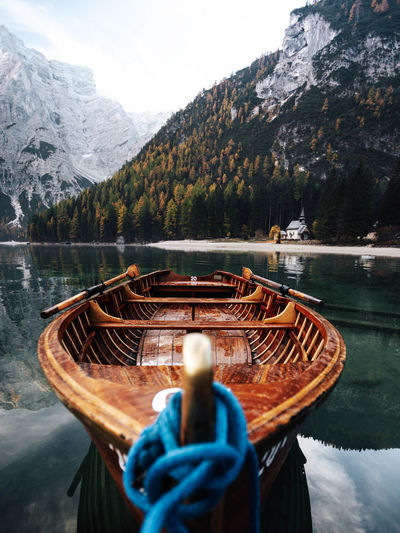 Boat moored on lake against mountains