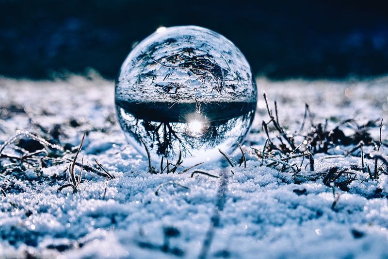 Close-up of ice crystal ball on frozen field