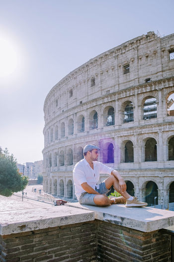 Man sitting against historical building