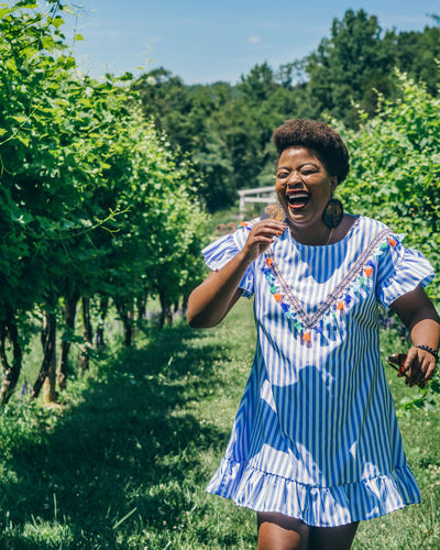 Smiling woman walking at vineyard