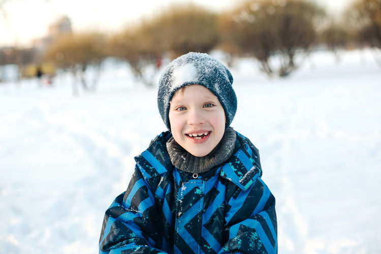 Portrait of smiling boy in snow outdoors