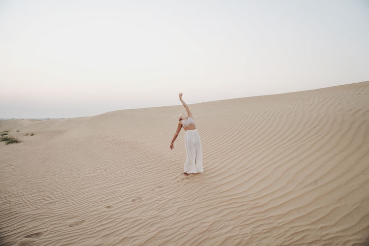 Woman in the desert with arms raised