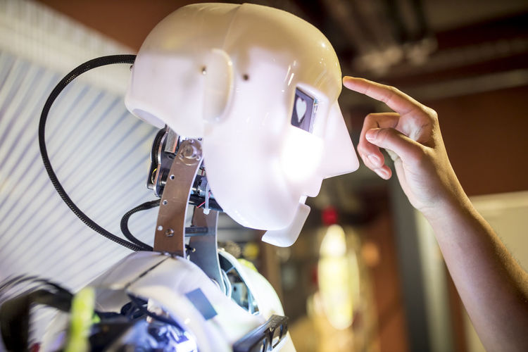 Developer touching human robot on head at workshop