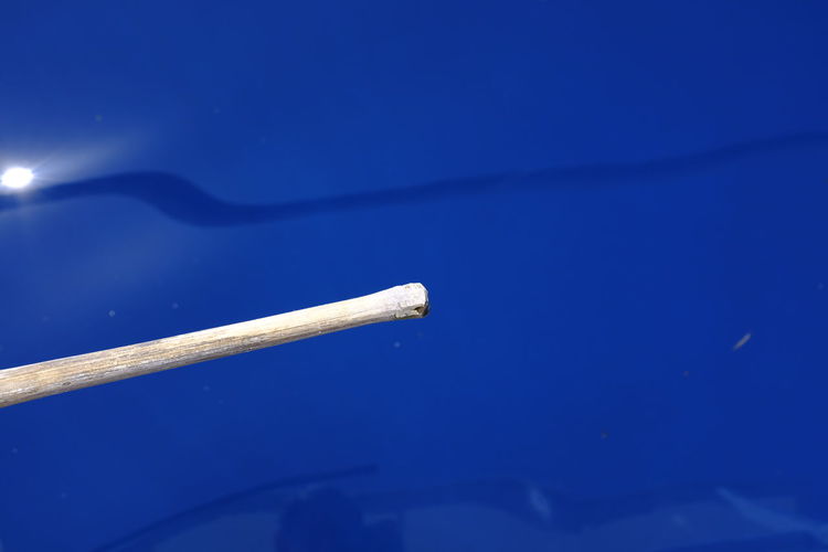 Close-up of cigarette against blue water