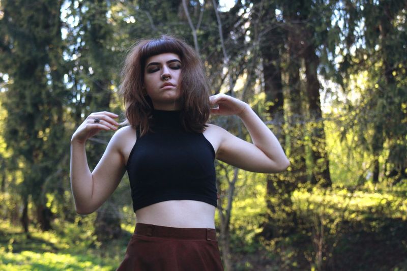 Portrait of beautiful young woman standing in forest