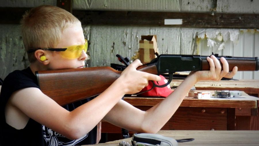 Boy practicing with rifle at shooting range