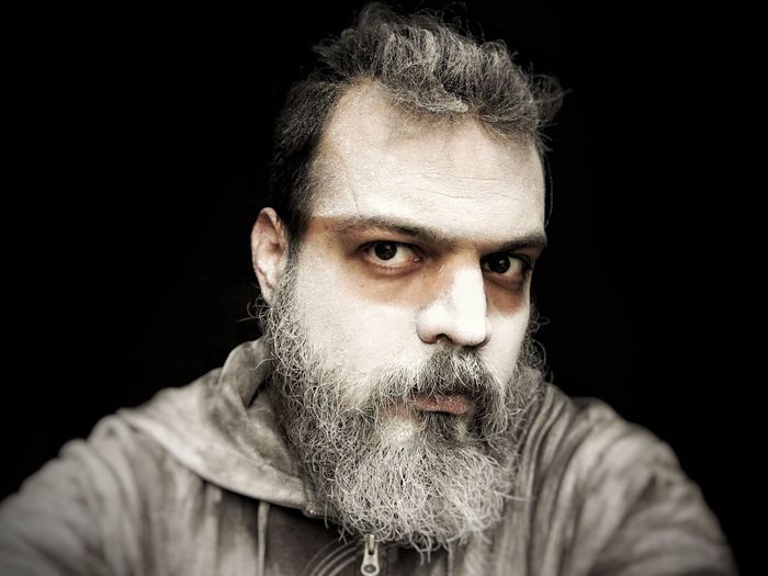 Close-up portrait of man against black background