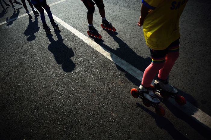 Low section of people roller skating on road